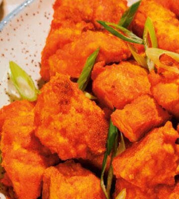 a close up of a bowl of spicy tofu nuggets with tahini ranch