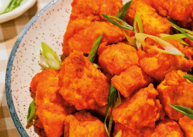 a close up of a bowl of spicy tofu nuggets with tahini ranch