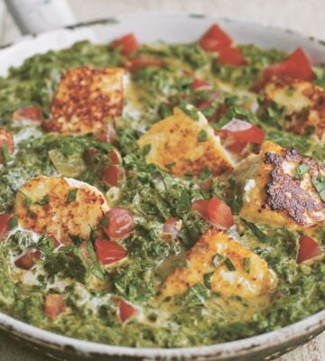 a pan of spinach tomato and tofu curry made with chili and plant-based cream