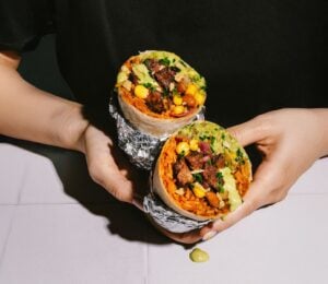 Photo shows someone holding the new Beyond Meat x Tortilla Beyond Steak Chimichurri burrito