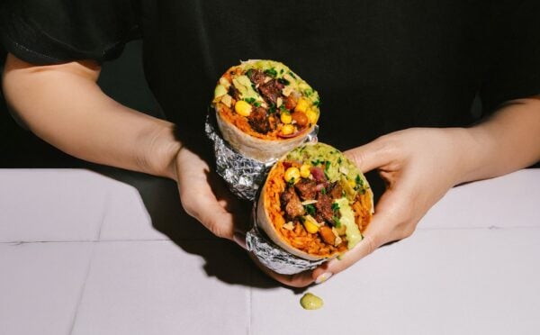 Photo shows someone holding the new Beyond Meat x Tortilla Beyond Steak Chimichurri burrito