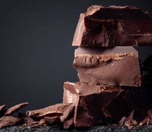 A pile of dark chocolate, which is associated with lowered type 2 diabetes risk, in front of a dark background