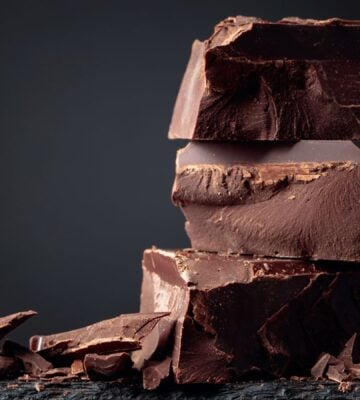 A pile of dark chocolate, which is associated with lowered type 2 diabetes risk, in front of a dark background