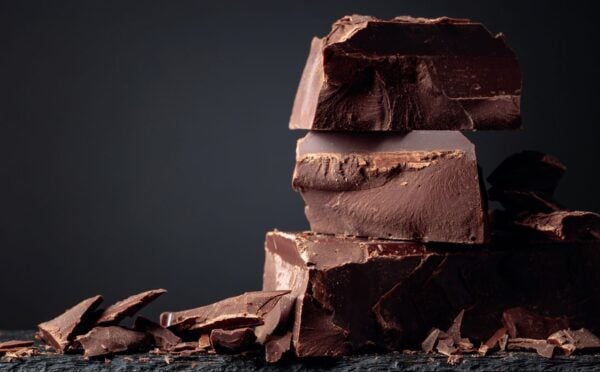 A pile of dark chocolate, which is associated with lowered type 2 diabetes risk, in front of a dark background