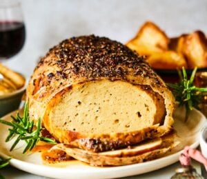 A vegan turkey roast on a plate at a Christmas dinner