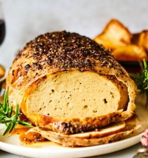 A vegan turkey roast on a plate at a Christmas dinner