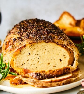 A vegan turkey roast on a plate at a Christmas dinner