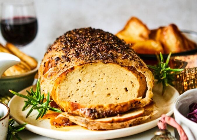 A vegan turkey roast on a plate at a Christmas dinner