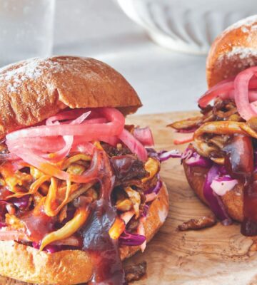 two BBQ pulled mushroom sandwiches with homemade creamy coleslaw and pickled onions