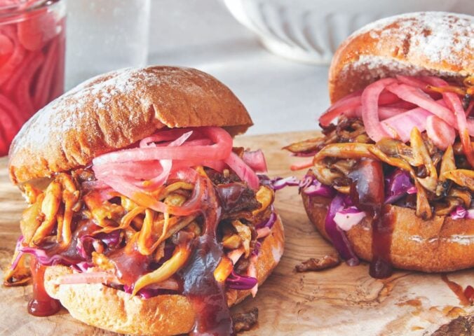 two BBQ pulled mushroom sandwiches with homemade creamy coleslaw and pickled onions