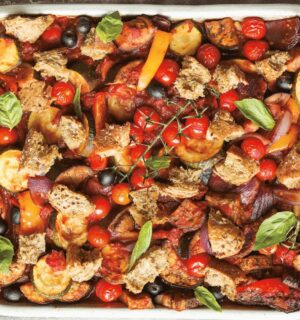 an Italian veggie sheet bake with eggplant, zucchini, olives, tomato, and bread