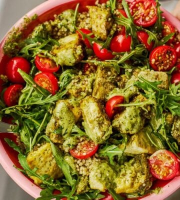 a baked pesto tofu bro bowl with tofu, quinoa, cherry tomatoes and rocket