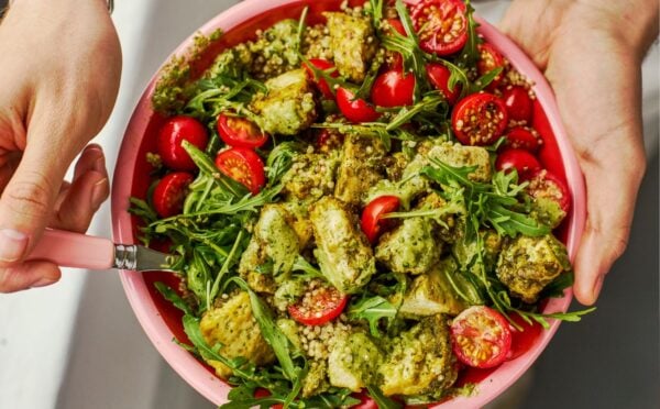 a baked pesto tofu bro bowl with tofu, quinoa, cherry tomatoes and rocket