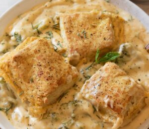 a bowl of broccoli cheddar cobbler with scratch-made biscuits