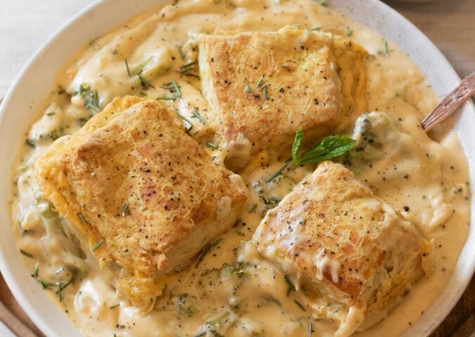 a bowl of broccoli cheddar cobbler with scratch-made biscuits