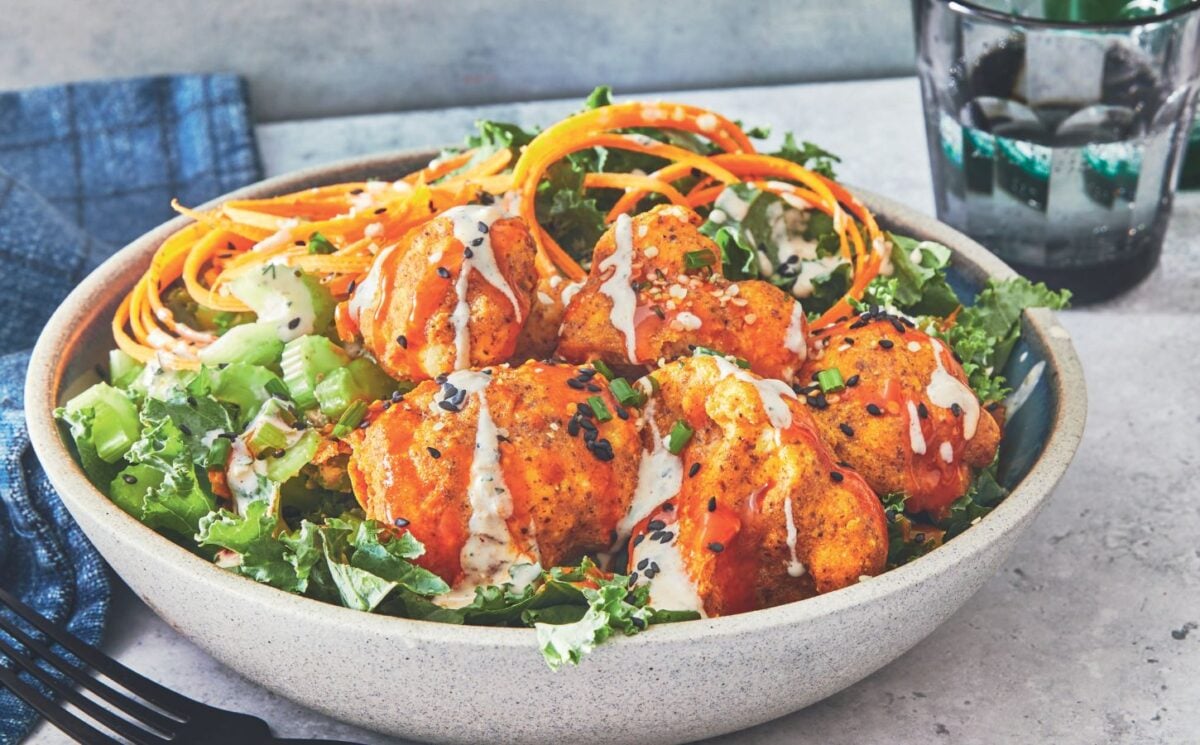 one of the buffalo cauliflower wings bowls with kale, hemp hearts, and sesame seeds