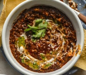 a bowl of buttery black dhal, a vegan dish served with poppadom