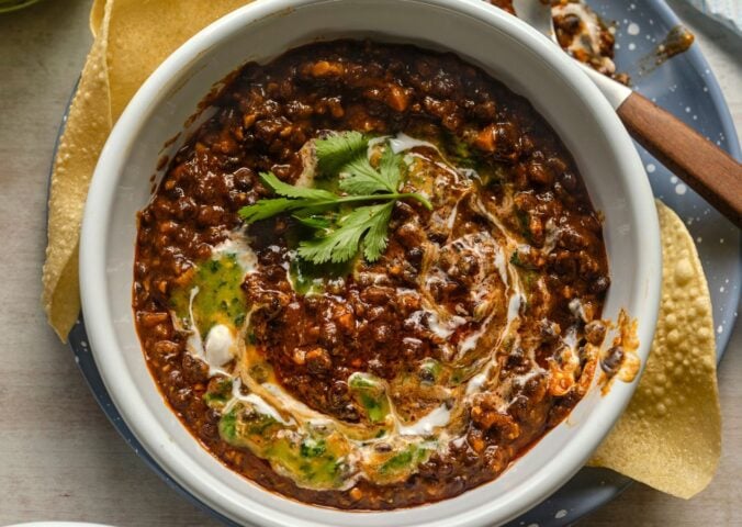 a bowl of buttery black dhal, a vegan dish served with poppadom