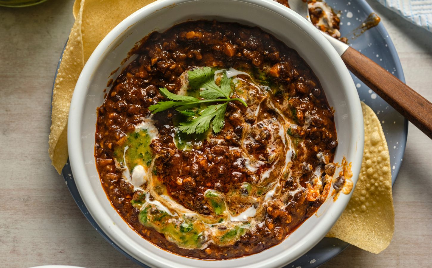 a bowl of buttery black dhal, a vegan dish served with poppadom