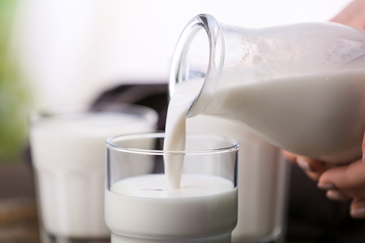 A person pouring milk into a glass