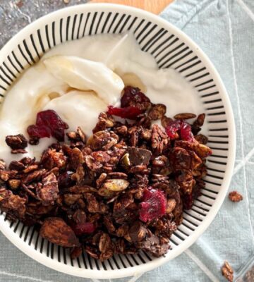 A bowl of vegan chocolate granola with dairy-free yogurt