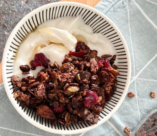 A bowl of vegan chocolate granola with dairy-free yogurt