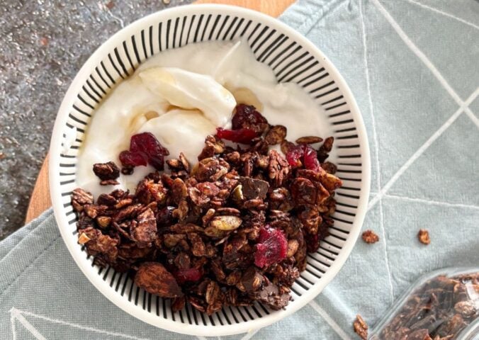 A bowl of vegan chocolate granola with dairy-free yogurt