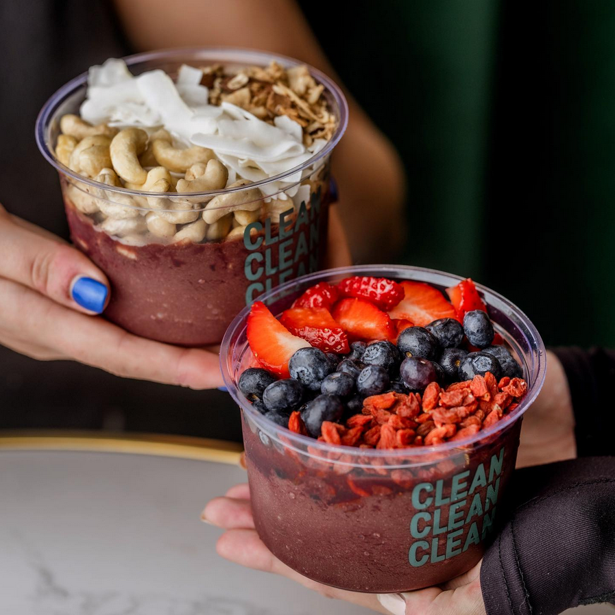 Photo shows two people holding dessert-style menu items from Clean Kitchen Club