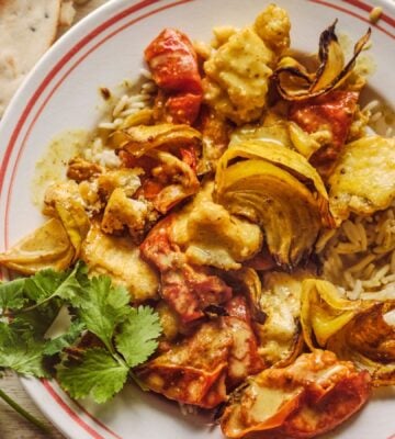 a bowl of creamy roasted tomatoey tofu curry with coriander