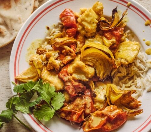 a bowl of creamy roasted tomatoey tofu curry with coriander