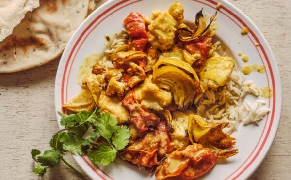 a bowl of creamy roasted tomatoey tofu curry with coriander