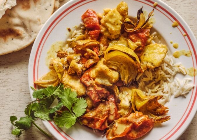 a bowl of creamy roasted tomatoey tofu curry with coriander