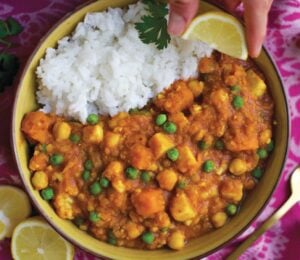 a bowl of curry spiced red lentil stew with rice