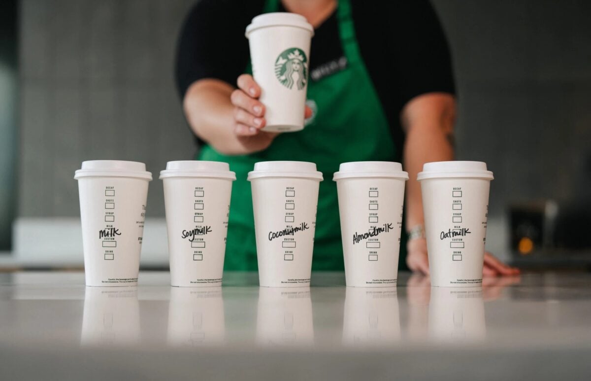 Starbucks coffee cups with the names of various dairy-free milks written on them