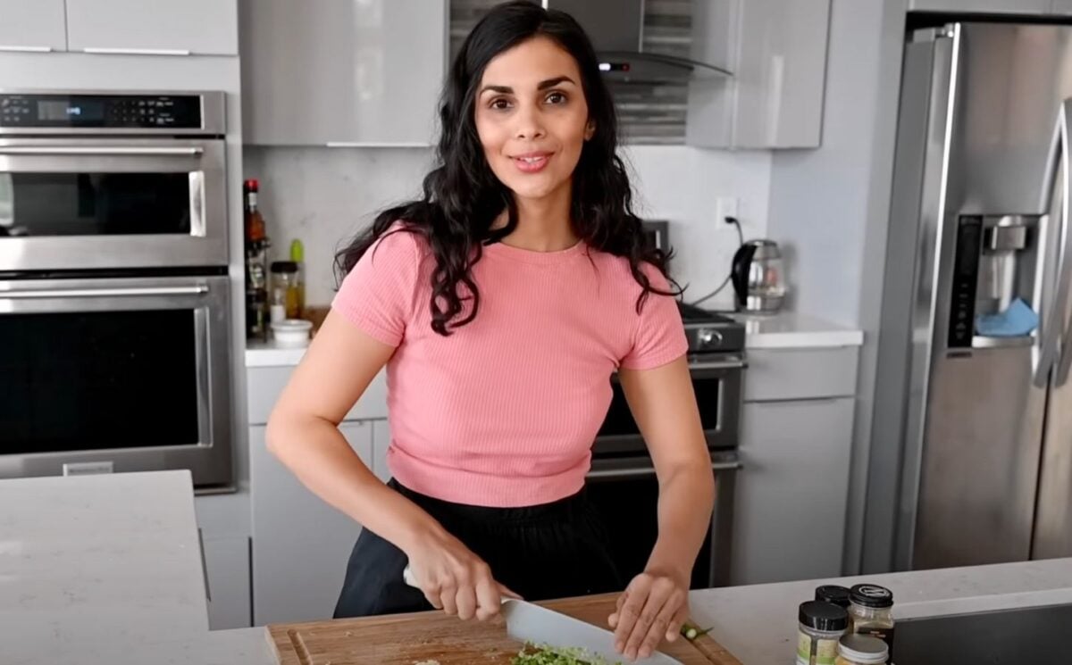 A still of vegan chef Nisha Vora (RainbowPlantLife) from a YouTube video showing her cooking her vegan red lentil recipe