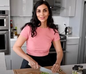 A still of vegan chef Nisha Vora (RainbowPlantLife) from a YouTube video showing her cooking her vegan red lentil recipe