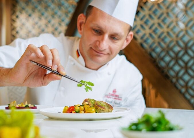 A chef preparing an Emirates vegan menu item