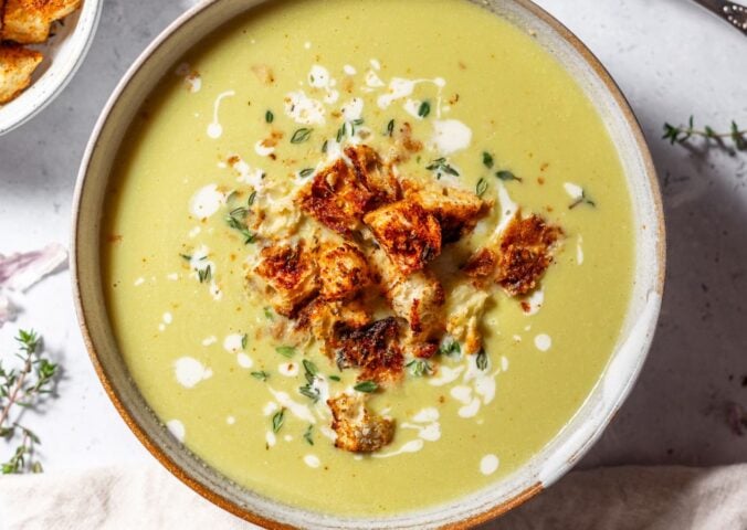 a bowl of vegan green asparagus soup made with celery, vegan cream, lemon zest, and thyme