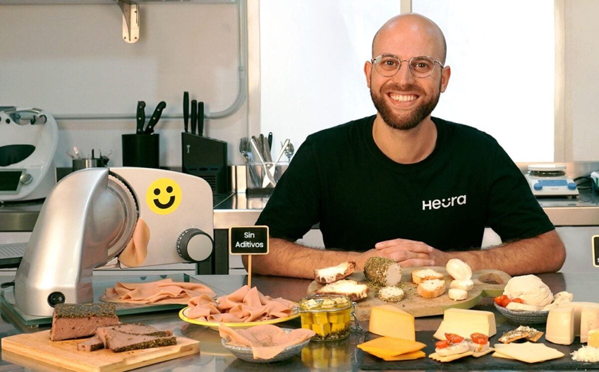 Heura founder Marc Coloma sitting with some of the plant-based meat company's products and equipment