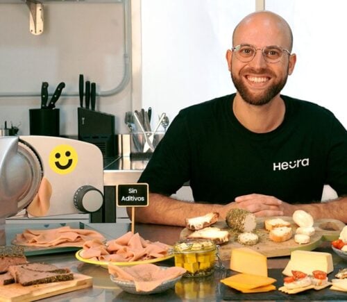 Heura founder Marc Coloma sitting with some of the plant-based meat company's products and equipment