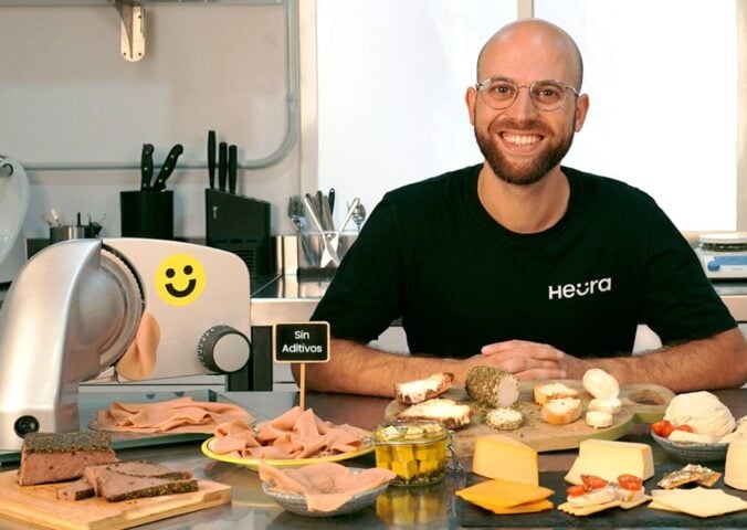 Heura founder Marc Coloma sitting with some of the plant-based meat company's products and equipment