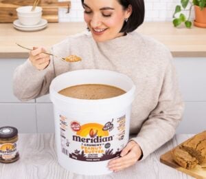 A woman eating a huge 10kg tub of Meridian peanut butter