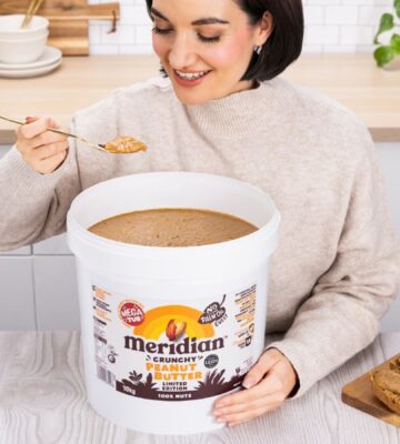 A woman eating a huge 10kg tub of Meridian peanut butter