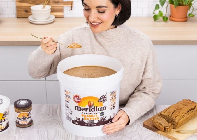 A woman eating a huge 10kg tub of Meridian peanut butter