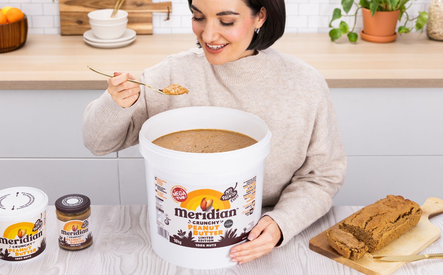 A woman eating a huge 10kg tub of Meridian peanut butter