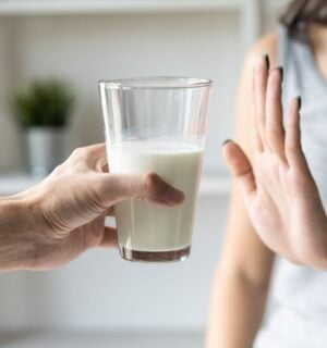 A person putting her hand up to reject a glass of dairy milk, which is linked to reduced risk of bowel cancer