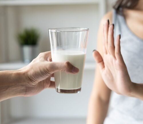 A person putting her hand up to reject a glass of dairy milk, which is linked to reduced risk of bowel cancer