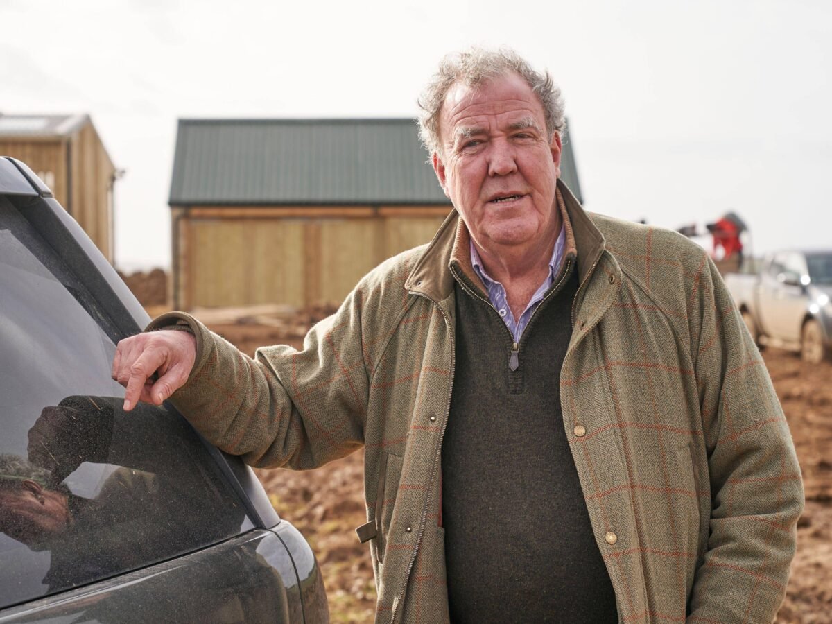 Photo shows Jeremy Clarkson standing next to a vehicle on his farm