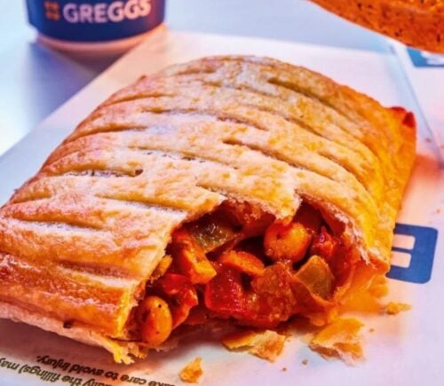 Photo shows the returning Greggs Spicy Vegetable Curry Bake alongside a cup of a coffee