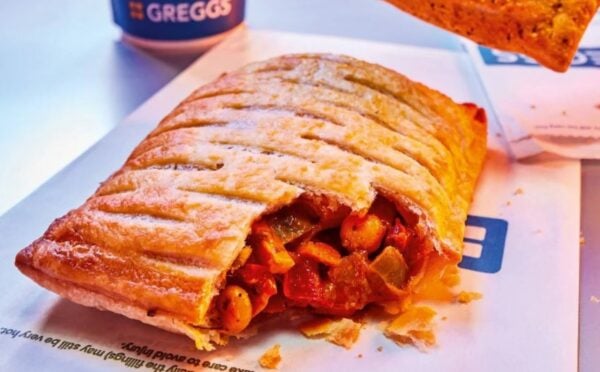 Photo shows the returning Greggs Spicy Vegetable Curry Bake alongside a cup of a coffee